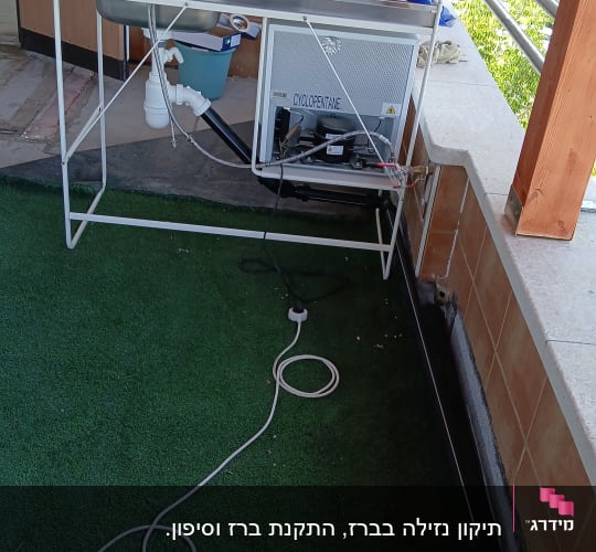 כיור עם ברז ומערכת צינורות על מרפסת